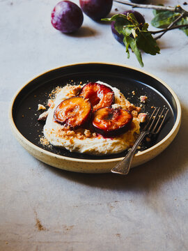 Poached plums with almond biscotti cream