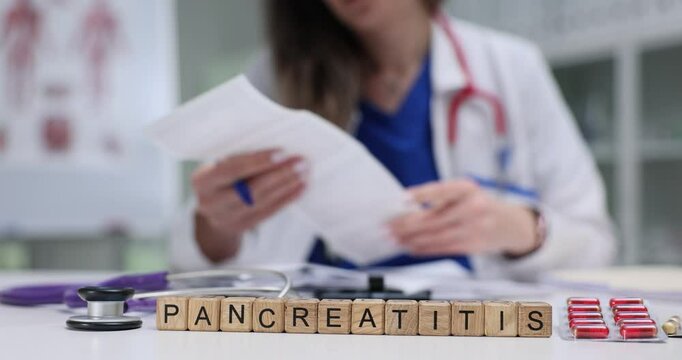 Female doctor holds ultrasound scan contemplating Pancreatitis diagnosis while seated at table. Medical condition of pancreatitis in hospital setting