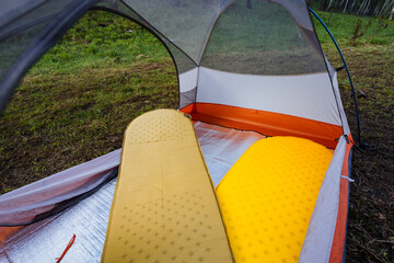Enjoy a cozy camping setup with two comfy air mattresses in a spacious tent, surrounded by natures...