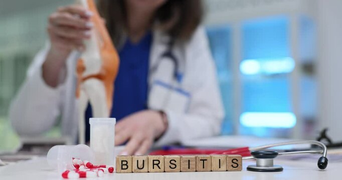 Female doctor presents anatomical model of knee joint while explaining Bursitis. Medical explanation of bursitis during consultation with patient