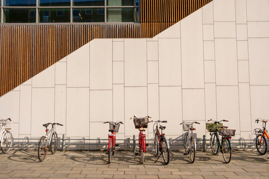 Row of bicycles parked in front of minimalist white wall, modern architecture, cycling culture, urban mobility and sustainability