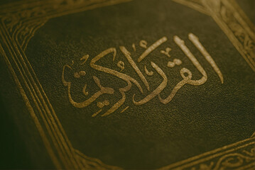 Close-Up of Aged Quran Cover with Dark Gold Calligraphy