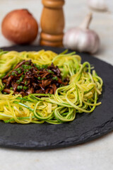 Zucchini spaghetti with shimeji on black stone plate