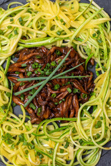 Zucchini spaghetti with shimeji on black stone plate