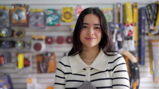 Young saleswoman smiling at the camera in a hardware store