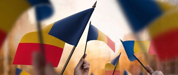 Chad flags in their hands on a blurred urban background