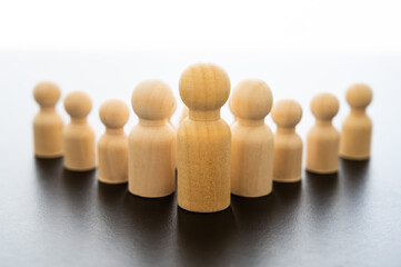 Conceptual representation, with wooden pawns, of a man alone in command, and followers who follow...