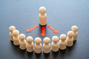 Conceptual representation, with wooden pawns, of a person who addresses other people who listen....