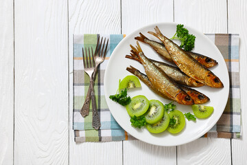 Hot smoked Baltic herrings with kiwi fruit slices