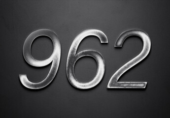 Chrome metal 3D number design of 962 on grey background.