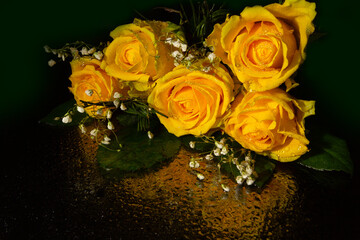 Yellow roses on a black mirror surface
