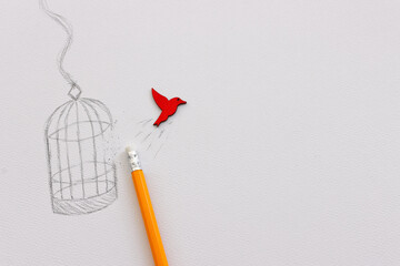 Concept image of wooden bird escaping cage. Idea of mental freedom or changing mindset