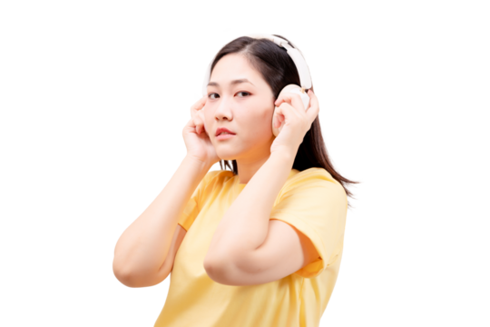 Asian young beautiful woman in a yellow shirt wearing headphones and a yellow shirt, listening with a focused expression. - Powered by Adobe
