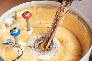 Corrosion and mineral deposits on the heating element of an electric boiler. Boiler maintenance and repair