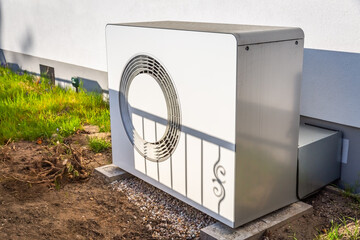 Air source heat pump installed outside a house, green renewable energy concept of heat pump