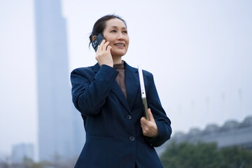 Businesswoman Talking on Phone with Laptop