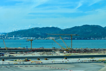 Construction site in Tung Chung, Hong Kong. Cranes truck working in construction site. Construction background, construction equipment crane background.