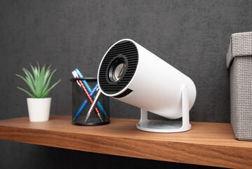 White projector with a lens on shelf