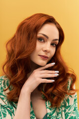 Captivating portrait of a beautiful woman with red hair against a vibrant yellow background