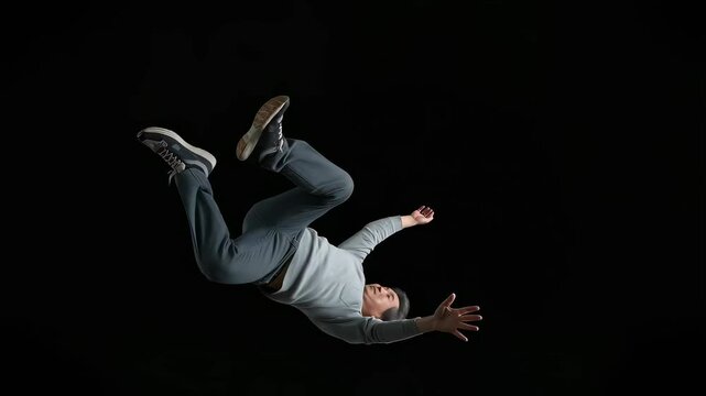 普段着の中年男性が、暗黒空間を落ちる、人生転落のイメージ