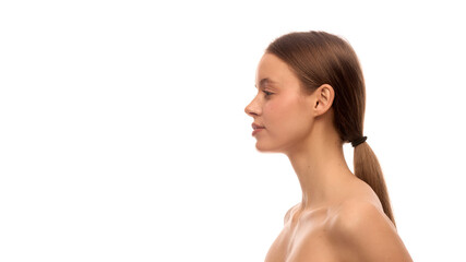 Fototapeta premium Side view of elegant young woman with tied back hair, straight profile, clean skin and relaxed posture with visible shoulders. Concept of double chin prevention, natural elegance, clean skin, haircare
