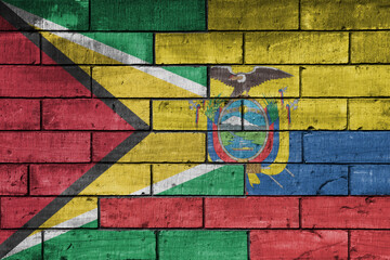 colourful painted big national flag of ecuador and flag of guyana on a massive old brick wall background. concept