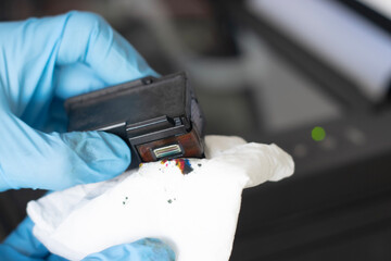 Side view of technician inspecting printer printhead.