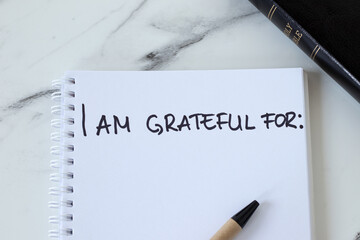 I am grateful for, handwriting in notebook with holy bible book. Top view. Gratitude and...