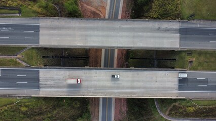 imagem aérea do rodoanel, sp, mostrando trânsito fluido de carros e caminhões em pista larga....