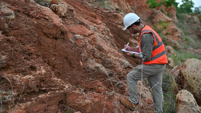 A geologist is using a steel rod to drill into a rock to obtain a rock sample for analysis