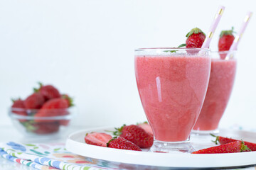 Strawberry breakfast smoothie in glass with white background. Close-up. Copy space.