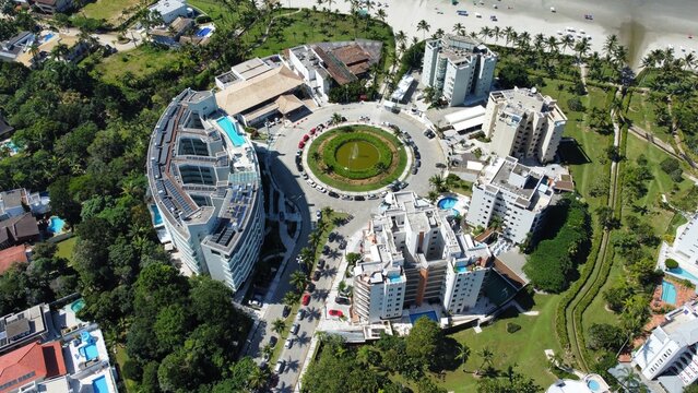 Vis&atilde;o a&eacute;rea da entrada da Praia de Riviera de S&atilde;o Louren&ccedil;o, em Bertioga, SP. A imagem mostra o acesso urbanizado, &aacute;reas verdes e o in&iacute;cio da faixa de areia com o mar ao fundo