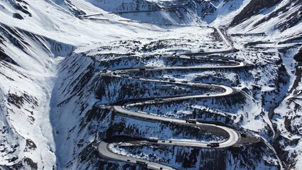 Foto aérea dos túneis e curvas sinuosas de Los Caracoles, Chile, revelando a beleza da estrada na cordilheira dos Andes. Destaque para a paisagem montanhosa e o trajeto desafiador © RNL Fotografia