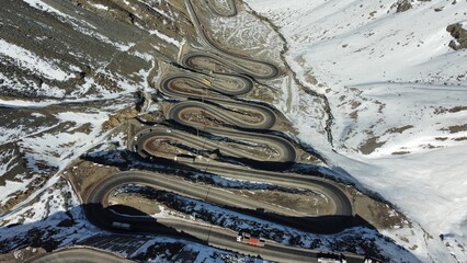 Imagem aérea de Los Caracoles no Chile, mostrando as curvas fechadas e a estrada que atravessa os Andes. O cenário destaca o relevo montanhoso e o desafio da rota para motoristas © RNL Fotografia