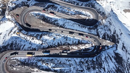 imagem aérea das curvas nevadas de los caracoles, no chile. estrada sinuosa coberta de neve entre montanhas dos andes. cenário impressionante de inverno e altitude extrema © RNL Fotografia