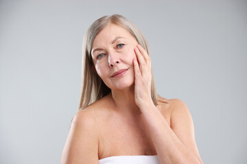 Woman with healthy skin on grey background