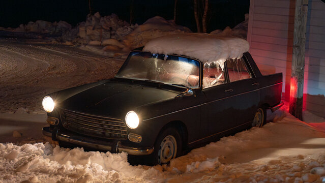 Fototapeta Vintage car in snowy nordic landscape at night