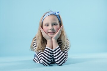 Cute little girl on light blue background