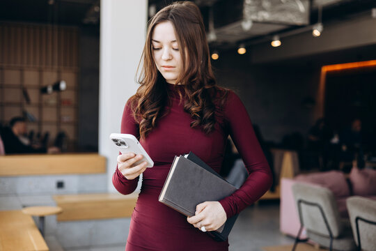 Young woman student checking phone