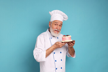 Professional pastry chef with delicious cake on light blue background