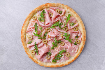 Rustic Mortadella Olive Pesto Pizza with Fresh Arugula Garnish