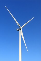 Single wind turbine against vivid blue sky