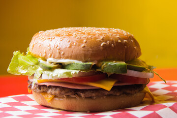 A visually appealing hamburger stacked high with fresh ingredients, melted cheese, and crunchy...