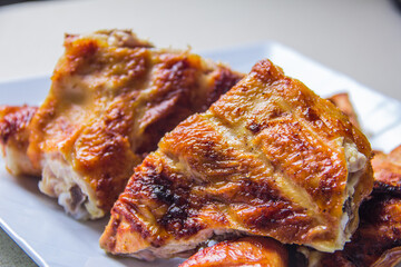 Succulent pieces of golden brown grilled chicken showcasing a crispy skin, perfect for gourmet...