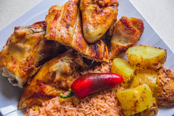 A beautiful presentation of grilled chicken, accompanied by rice and roasted potatoes, captures the essence of home-cooked meals that are both comforting and satisfying.