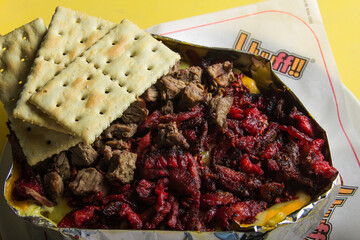 An appealing serving of savory beef and al pastor meat topped with cheese and accompanied by crisp...