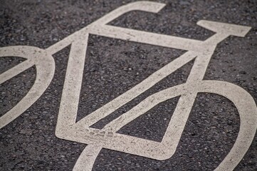 White bicycle symbol painted on asphalt suggests bike lane