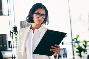 Confident businesswoman in professional attire shaping workplace success in a modern office...