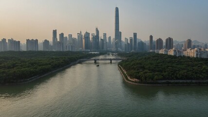 Fototapeta premium Bustling cityscape at dusk reveals tranquil river winding through modern skyscrapers. Tallest building dominates skyline, reflecting fading light. Bridge spans water, surrounded by lush greenery.