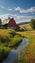 Obraz premium Red barn stands tall in lush green field under clear blue sky with scattered clouds. Small stream winds through foreground, flanked by wildflowers, grasses, leading eye toward barn.
